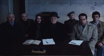 Movie still from “Confidence” (1980), directed by István Szabó – A group of people sitting around a table; Medium shot, High angle