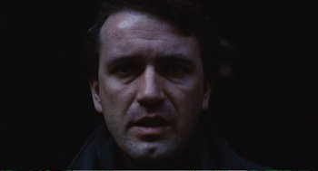 Movie still from “Confidence” (1980), directed by István Szabó – A man's face in the dark; Close Up shot, Low angle