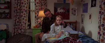 Movie still from “Contact” (1997), directed by Robert Zemeckis – A man sitting next to a young girl in a bedroom; Medium shot, Over the shoulder angle