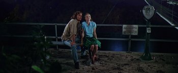Movie still from “Contact” (1997), directed by Robert Zemeckis – A man and a woman sitting next to each other on the beach; Wide shot, Low angle