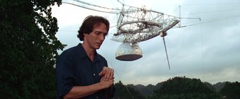 Movie still from “Contact” (1997), directed by Robert Zemeckis – A man standing in front of a large metal structure; Medium shot, Low angle