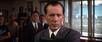 Movie still from “Contact” (1997), directed by Robert Zemeckis – A man in a suit and tie holding a tablet; Close Up shot, Low angle