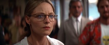 Movie still from “Contact” (1997), directed by Robert Zemeckis – A person wearing glasses and a suit; Close Up shot, Over the shoulder angle