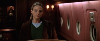 Movie still from “Contact” (1997), directed by Robert Zemeckis – A woman standing in front of an airplane; Medium shot, Low angle