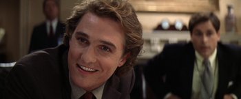 Movie still from “Contact” (1997), directed by Robert Zemeckis – A person wearing a suit and tie smiling; Close Up shot, Over the shoulder angle