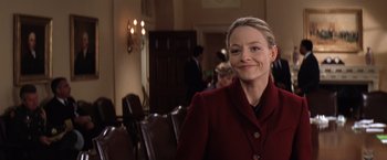 Movie still from “Contact” (1997), directed by Robert Zemeckis – A woman in a red coat smiling for the camera; Close Up shot, Over the shoulder angle