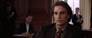 Movie still from “Contact” (1997), directed by Robert Zemeckis – A man sitting in front of a woman in a courtroom; Close Up shot, Over the shoulder angle