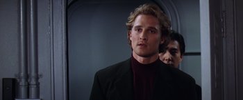 Movie still from “Contact” (1997), directed by Robert Zemeckis – A man with long blonde hair standing in front of a mirror; Close Up shot, Over the shoulder angle