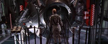 Movie still from “Contact” (1997), directed by Robert Zemeckis – A man in a suit is walking down a set of stairs; Wide shot, Overhead angle