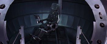 Movie still from “Contact” (1997), directed by Robert Zemeckis – An airplane seat in the middle of a room; Wide shot, Overhead angle