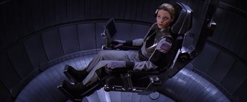 Movie still from “Contact” (1997), directed by Robert Zemeckis – A woman sitting in a chair with a lap top computer; Wide shot, High angle