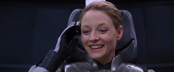 Movie still from “Contact” (1997), directed by Robert Zemeckis – A woman in a metallic suit smiling for the camera; Close Up shot, Over the shoulder angle