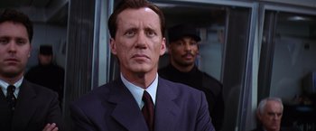 Movie still from “Contact” (1997), directed by Robert Zemeckis – A man in a suit and tie standing next to another man in a suit; Close Up shot, Low angle