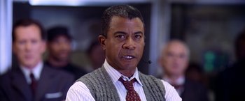 Movie still from “Contact” (1997), directed by Robert Zemeckis – A man wearing a tie and a sweater vest; Close Up shot, Low angle