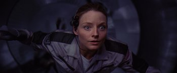 Movie still from “Contact” (1997), directed by Robert Zemeckis – A woman wearing headphones and looking into the camera; Close Up shot, Overhead angle