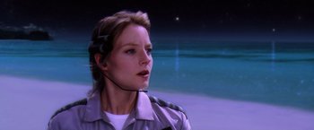 Movie still from “Contact” (1997), directed by Robert Zemeckis – A woman with a headset in front of a body of water; Close Up shot, Over the shoulder angle