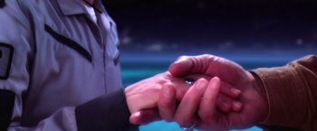 Movie still from “Contact” (1997), directed by Robert Zemeckis – A person holding a wedding ring; Extreme Close Up shot, High angle