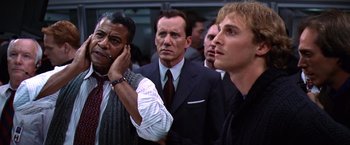 Movie still from “Contact” (1997), directed by Robert Zemeckis – A group of men standing next to each other in a room; Medium shot, Low angle