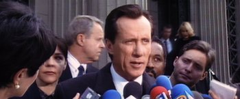 Movie still from “Contact” (1997), directed by Robert Zemeckis – A person talking on a microphone; Close Up shot, Over the shoulder angle