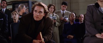 Movie still from “Contact” (1997), directed by Robert Zemeckis – A group of people sitting in a room with books; Medium shot, Over the shoulder angle