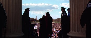 Movie still from “Contact” (1997), directed by Robert Zemeckis – A crowd of people gathered in front of a building; Extreme Wide shot, High angle