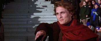 Movie still from “Contact” (1997), directed by Robert Zemeckis – A man in a red scarf sitting on some steps; Close Up shot, Over the shoulder angle