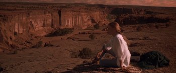 Movie still from “Contact” (1997), directed by Robert Zemeckis – A woman sitting on the side of a cliff; Wide shot, High angle