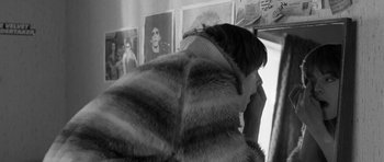 Movie still from “Control” (2007), directed by Anton Corbijn – A woman in a fur coat looking at a picture of herself; Close Up shot, High angle