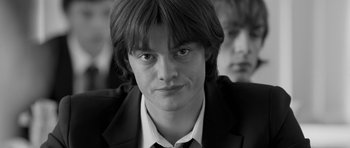 Movie still from “Control” (2007), directed by Anton Corbijn – Black and white photograph of a young man in a suit; Close Up shot, Low angle