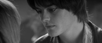 Movie still from “Control” (2007), directed by Anton Corbijn – A person's face in a black and white photo; Close Up shot, Low angle