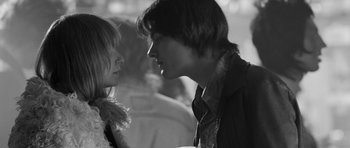 Movie still from “Control” (2007), directed by Anton Corbijn – A man and a woman face to face in a black and white photo; Close Up shot, Over the shoulder angle