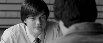 Movie still from “Control” (2007), directed by Anton Corbijn – A man in a suit and tie looking at another man in a suit and tie; Close Up shot, Over the shoulder angle