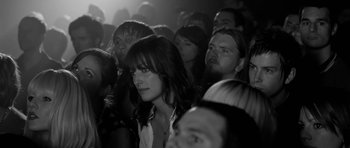 Movie still from “Control” (2007), directed by Anton Corbijn – A group of people sitting in a room; Close Up shot, High angle