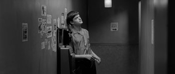Movie still from “Control” (2007), directed by Anton Corbijn – Black and white photograph of a young man leaning up against a wall; Medium shot, Low angle