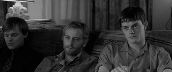 Movie still from “Control” (2007), directed by Anton Corbijn – A man and a woman sitting on a couch together; Close Up shot, Over the shoulder angle