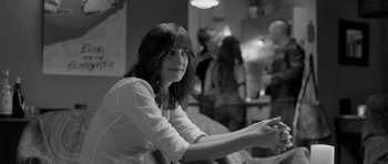 Movie still from “Control” (2007), directed by Anton Corbijn – Black and white photograph of a woman sitting in a room; Medium shot, Over the shoulder angle