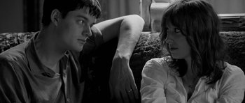 Movie still from “Control” (2007), directed by Anton Corbijn – A man and a woman sitting next to each other on a couch; Close Up shot, Over the shoulder angle