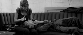 Movie still from “Control” (2007), directed by Anton Corbijn – A man and a woman laying on a couch; Medium shot, High angle