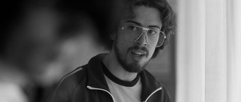 Movie still from “Control” (2007), directed by Anton Corbijn – Black and white photograph of a young man wearing glasses; Close Up shot, Low angle