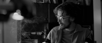 Movie still from “Control” (2007), directed by Anton Corbijn – Black and white photograph of a young man smoking a cigarette; Close Up shot, Over the shoulder angle