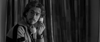 Movie still from “Control” (2007), directed by Anton Corbijn – A man with glasses talking on a phone; Close Up shot, Low angle