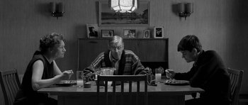 Movie still from “Control” (2007), directed by Anton Corbijn – An older man sitting at a table in front of a bowl of soup; Medium shot, Over the shoulder angle