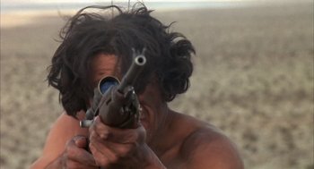 Movie still from “Coogan's Bluff” (1968), directed by Don Siegel – A man is holding a gun in his hands; Close Up shot, Low angle
