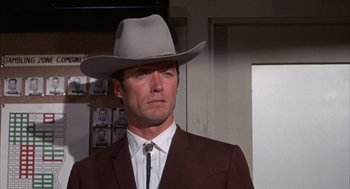 Movie still from “Coogan's Bluff” (1968), directed by Don Siegel – A man wearing a suit and a cowboy hat; Close Up shot, Low angle