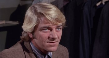 Movie still from “Coogan's Bluff” (1968), directed by Don Siegel – A person wearing a suit and tie; Close Up shot, Low angle