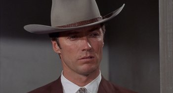 Movie still from “Coogan's Bluff” (1968), directed by Don Siegel – A person wearing a suit and a cowboy hat; Close Up shot, Low angle