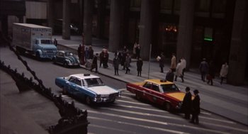 Movie still from “Coogan's Bluff” (1968), directed by Don Siegel – A group of people walking across a street with cars; Extreme Wide shot, High angle