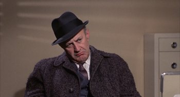 Movie still from “Coogan's Bluff” (1968), directed by Don Siegel – An older man wearing a hat and a coat; Close Up shot, Low angle