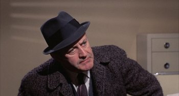 Movie still from “Coogan's Bluff” (1968), directed by Don Siegel – An older man wearing a hat and a suit; Close Up shot, Low angle