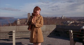 Movie still from “Coogan's Bluff” (1968), directed by Don Siegel – A woman standing on a ledge in front of a city skyline; Medium shot, Low angle